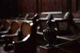 A photo of wooden pews in a courthouse.