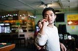 A man prepares to throw a dart with a focused expression.