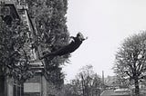 Yves Klein’s “Leap Into The Void” shows a man in a suit falling off a roof and the ground below.