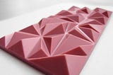 A thin bar of ruby chocolate. Instead of being scored into squares/rectangles, it’s in three-dimensional triangle shapes.