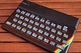 A slightly tatty-looking Sinclair ZX Spectrum 48K on a wooden table