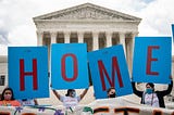 DACA supporters hold up signs that read “HOME” outside the Supreme Court on June 18th, 2020.