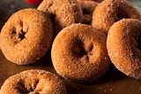 Cinnamon-sugar donuts on a table.