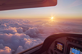 Image of clouds under the cockpit of a small airplane.