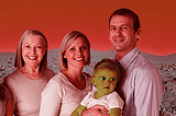 2 parents, 2 grandparents, a teenager, and a baby pose for a family portrait on a red martian landscape