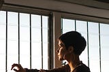 Woman thinking near a window.