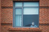 An older female resident at The Leonard Florence Center for Living looks outside her window.