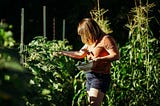 Female farmer gathering vegetables from the garden. Slow Living with Stacey Langford.