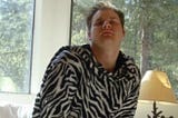 A young me adorned in a zebra-print snuggie luxuriates atop a pile of very real crypto coins