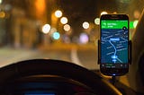 Google Maps on a phone mounted above a car dashboard.