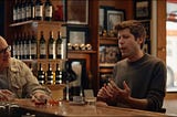 Jony Ive and Sam Altman discussing future AI devices in a bar