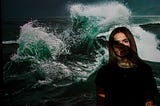 woman standing in front of wave