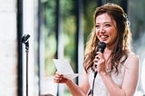 A young woman is giving speech during an event.