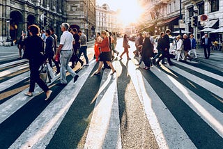 A group of pedestrians cross the street in a European city