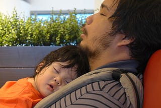 Joem Antonio sleeps as baby Leroy also sleeps in a carrier