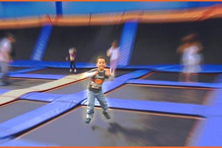 My son jumping in a square at indoor trampoline park.