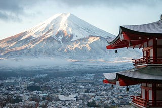 Mount Fuji in the background, red Japanese shrine in the foreground.