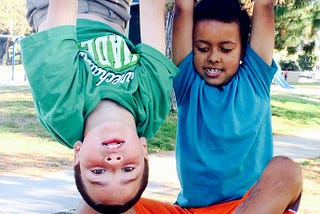 My son, right, with his friend hanging from the monkey bars.
