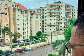 Tomiwa looking out the window from an apartment in Nigeria