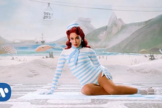 Anitta, posing in a throwback striped, sleeved bathing suit from her 2021 music video, “Girl From Rio.”