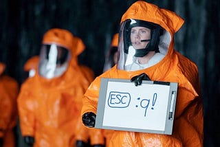 Amy Adams is holding a sign in an attempt to communicate with aliens in the film “Arrival”, but instead of showing the word “Human” it shows the command to exit Vim