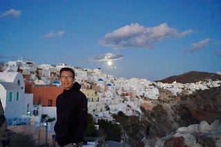 Photo of author in Santorini, Greece, during a blackout with a full moon!