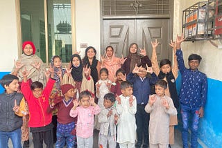 Educators and learners at Sadhoke Deaf Reach School making the “I love you” hand sign.