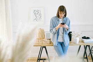 woman using her smartphone to check email (that’s what I’m saying she’s using the phone for)