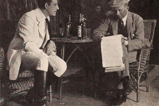 An image of two men reading a script in 1920