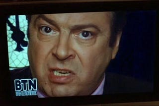 Lewis Prothero, a Trump-resembling character from V for Vendetta, speaks on a television channel from the film called BTN.