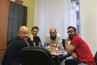 Auf dem Bild sind vier Autore von Slow News an einem Tisch sitzend zu sehen.