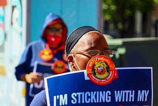 A striking union member holds up a protest sign.