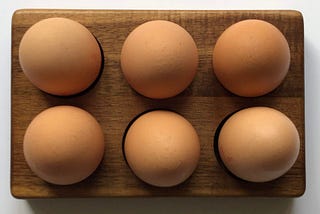 half a dozen brown eggs in a carton