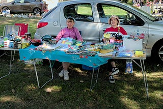 A picture of two people selling clothes at a market stall