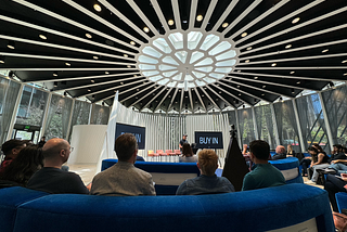 Photo of the interior of the SVB Experience Center with PJ Onori standing in from of a small audience talking about Buy-in.