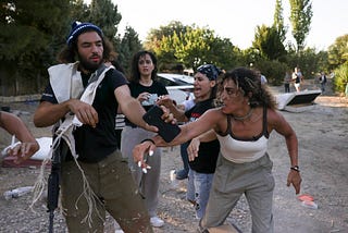 Alice Kisiya (right, front) confronts a settler holding a phone (left, front).