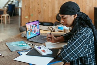 Designer working with paper drawings and a ditial Kanban Tool board