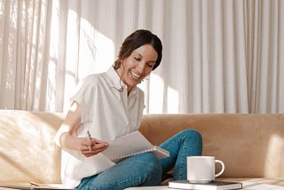 My Spring Morning Routine And How To Make Yours In No Time. the lazy gal medium.com women sitting down on couch reading sejal ghanate