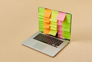 Laptop screen with organized lines of colored sitcky notes down the screen