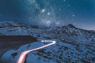 a photo of snowy mountains and starry night sky