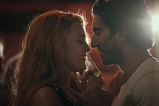 Blake Lively as Lily Bloom and Justin Baldoni as Ryle Kincaid dancing close together, backlit by a spotlight.