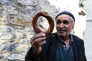 An old man gazes adoringly at a pretzel