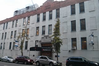 A gray four story building on the outside.