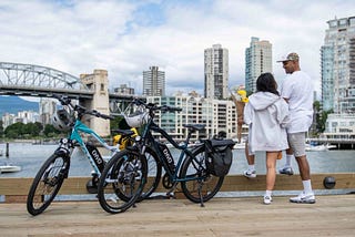 A couple stand by their e-bikes on a dock
