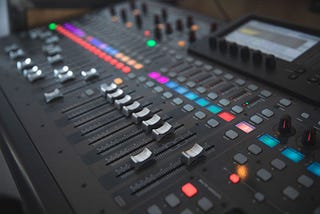 Photo of an audio engineering soundboard with sliders