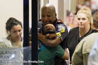 This is a picture of a Dallas Police Officer mourning his colleagues who were murdered by snipers.