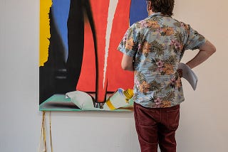 Photo of a person staring at a modern art painting of a heal show squishing a tube of paint colour