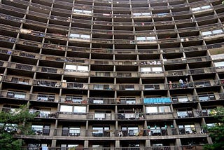 A photo of a wall of balconies of lower-income units taken from the ground.