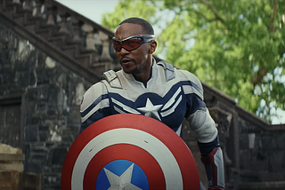 Anthony Mackie as Sam Wilson, the new Captain America, holding his iconic shield and decked out in a white and blue uniform.