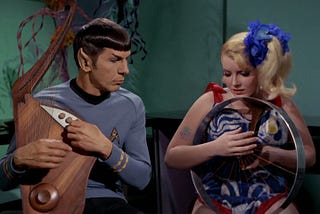 Spock strums his Vulcan lyre with one of the space hippies. Not exactly The Beatles, but…